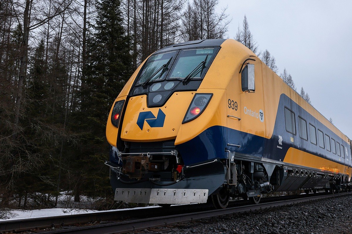 Northlander passenger train travelling through a wooded Northern Ontario rail corridor