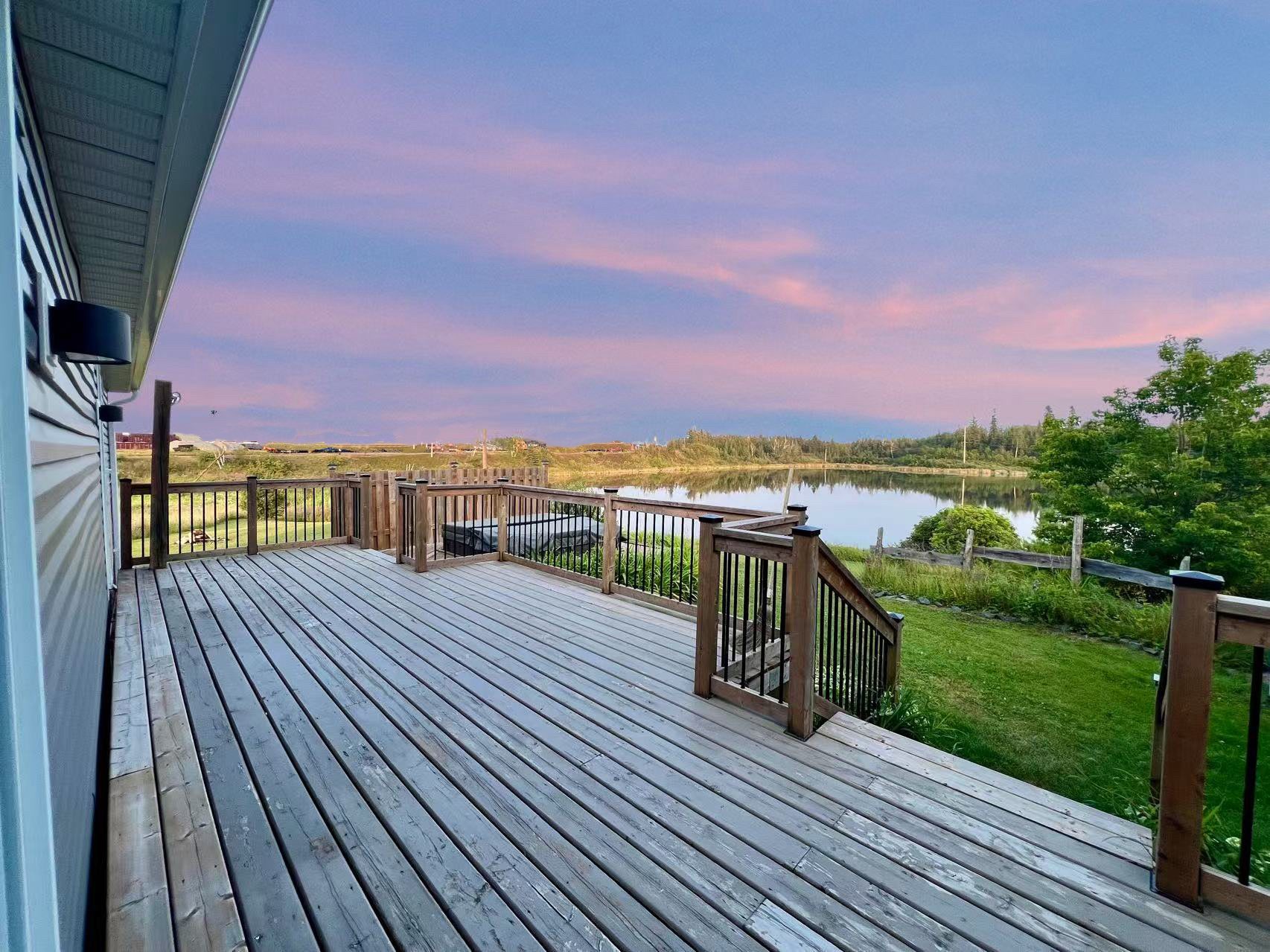 A deck overlooking water and open green space at Cochrane Mobile Home Park