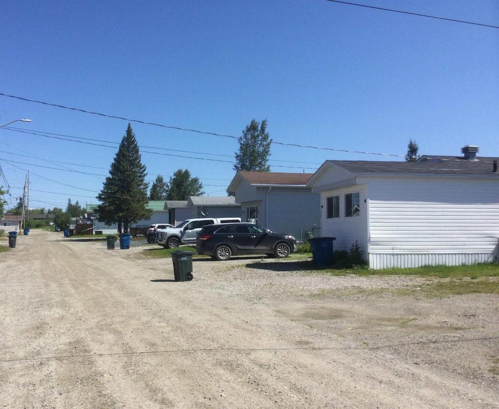 A gravel road and homes inside Cochrane Mobile Home Park