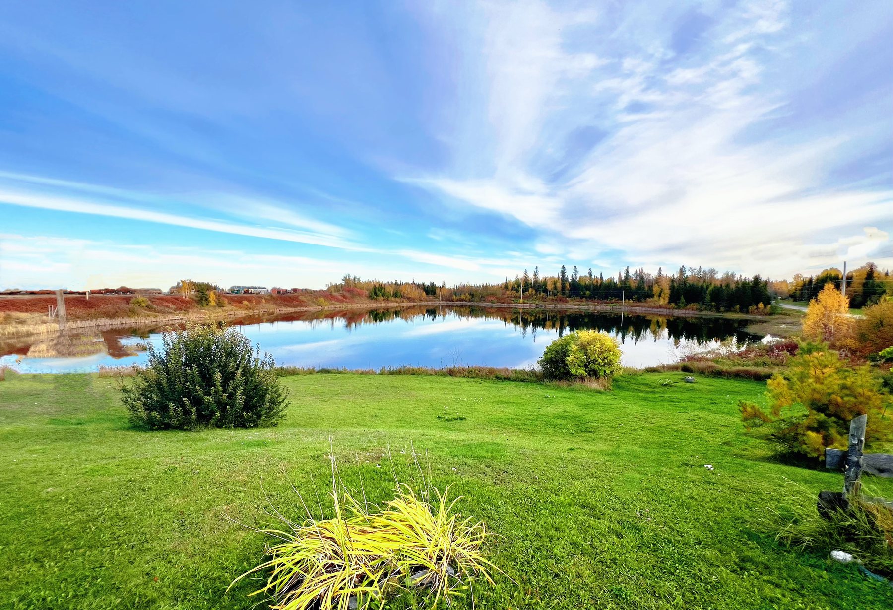 Open grass and water views near Cochrane Mobile Home Park